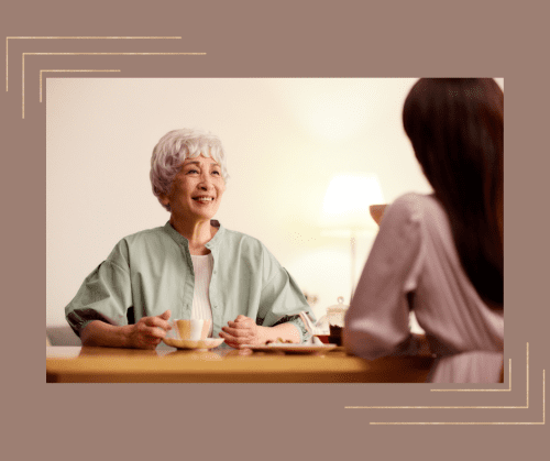 Two women have a conversation at a table.