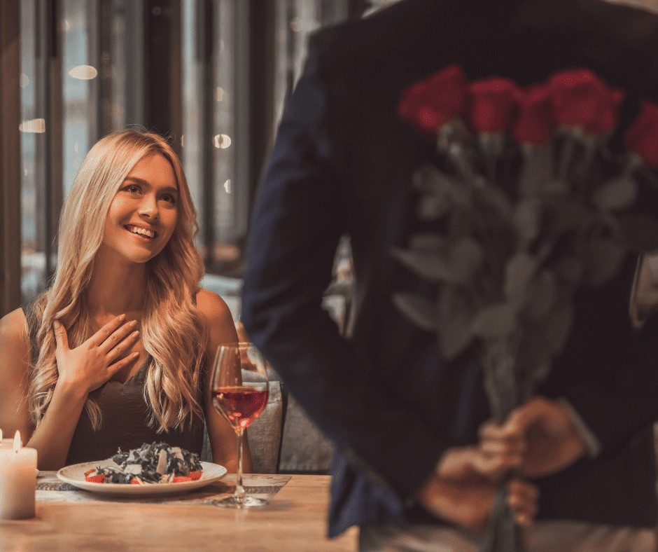Man and woman on first date. Man holding roses behind his back.