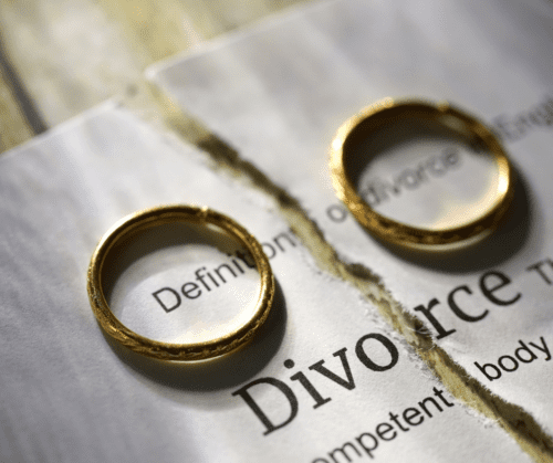Divorce papers ripped in half with wedding rings on each side