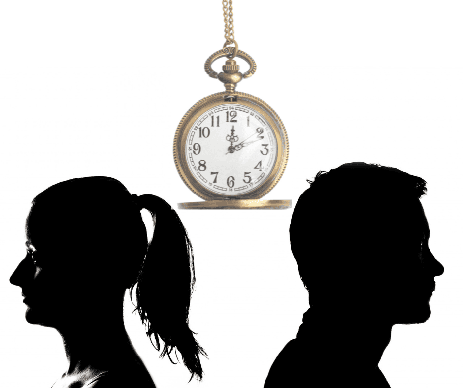 Silhouette of male and female couple facing away from each other with pocket watch hanging over them.