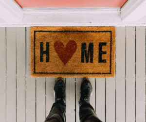 Downward view of Home welcome doormat in front of house