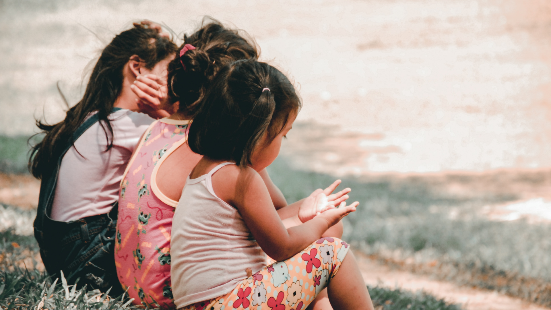 three little girls photographed sitting down from behind