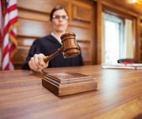 Female judge banging gavel in court room