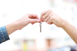 Close up of man and woman holding a house key.