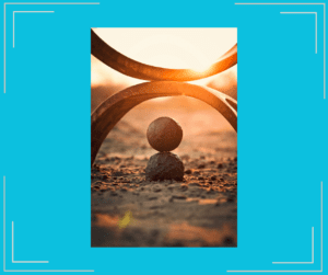 Rocks in sand under sculpture during sunset.