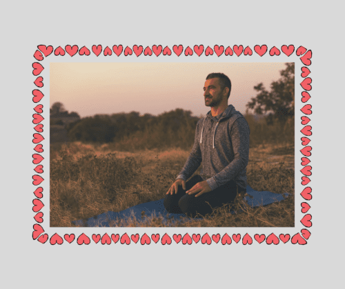 Man meditating on a yoga mat in the middle of a meadow at sunrise as part of mindfulness training. 